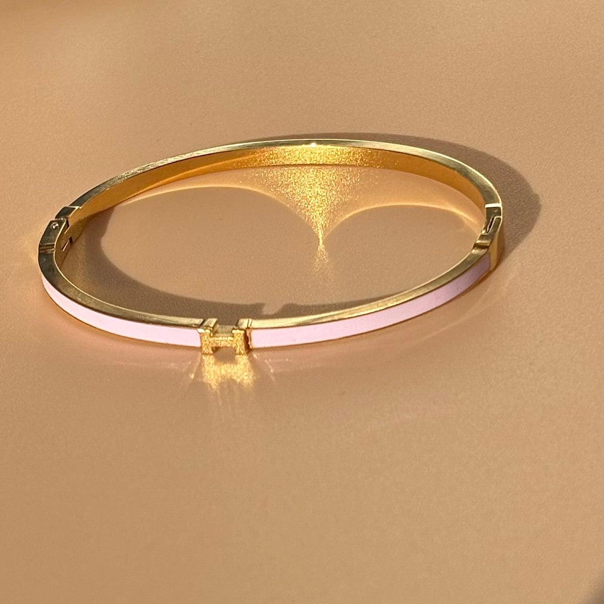 Gold bracelet on a beige background
